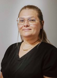Heather in black scrubs smiling for headshot