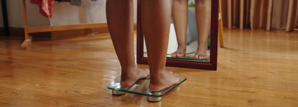 Woman standing on scale in front of mirror 