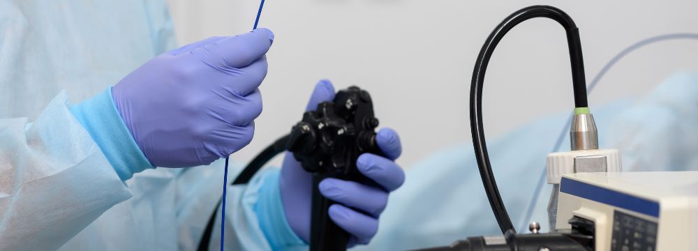 Surgeon holding endoscope while wearing gloves in operating room 