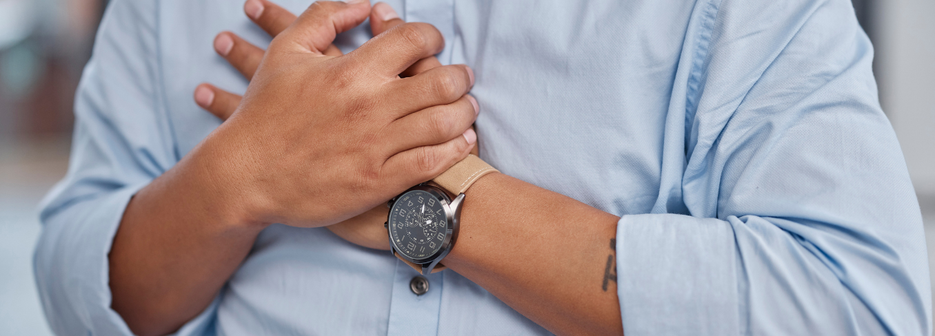 Man holding hands over heart in pain 